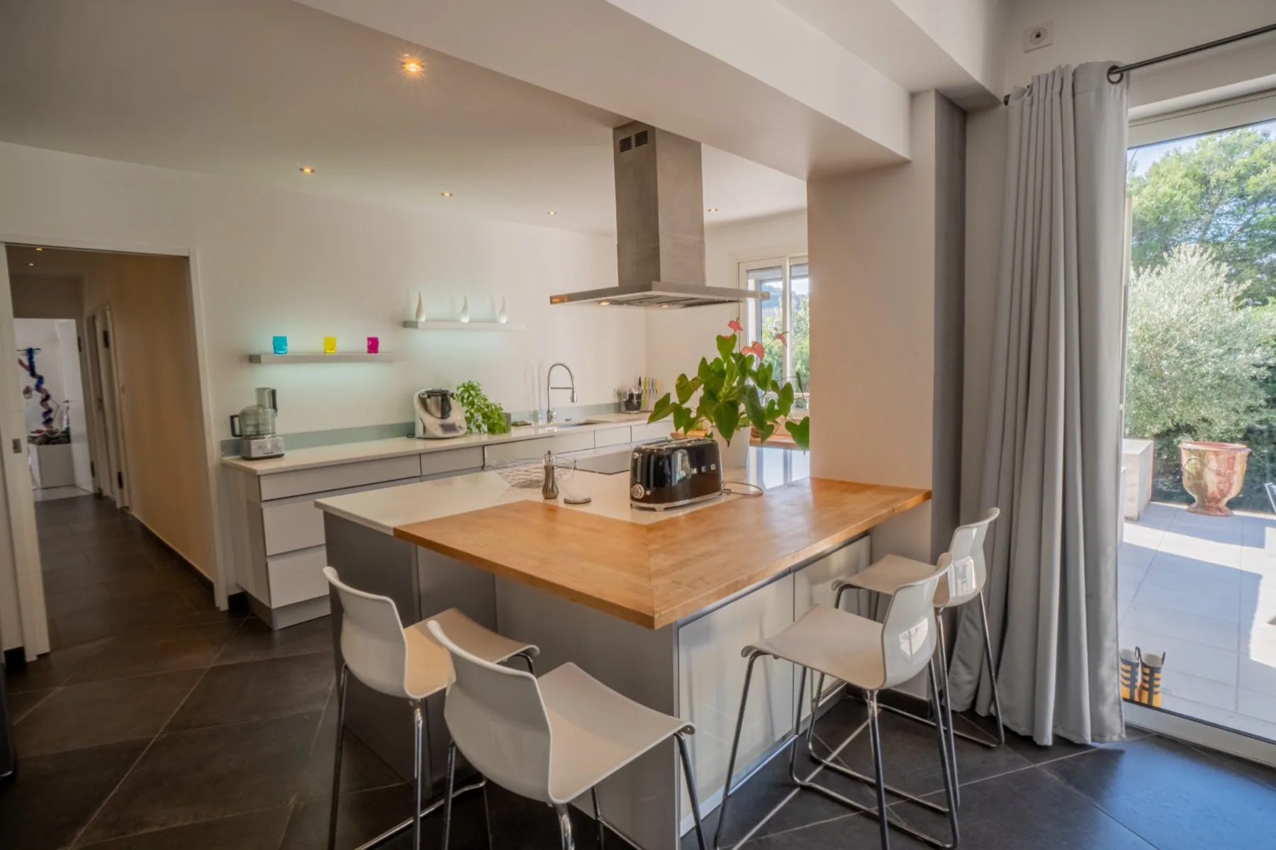 Cuisine ouverte avec îlot et accès à la terrasse
